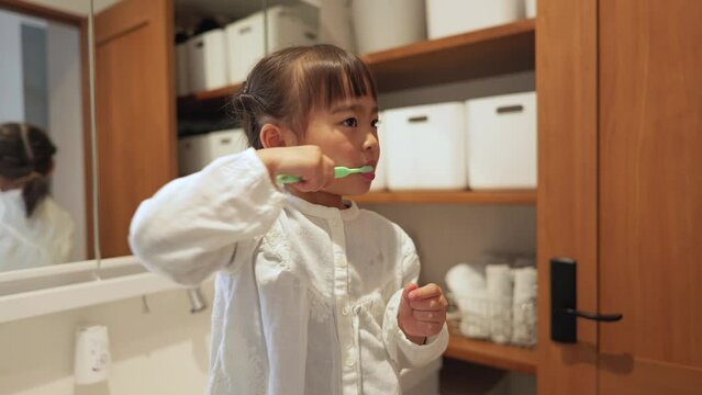 洗面所で1人で歯を磨く女の子