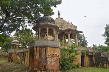 Obraz premium Majestic Royal Cenotaphs Amidst Verdant Greenery Under Cloudy Skies at Maharani Ki Chhatri ,Jaipur, Rajasthan, India