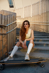 Teenage woman skateboarder sitting on stairs enjoying outdoors lifestyle