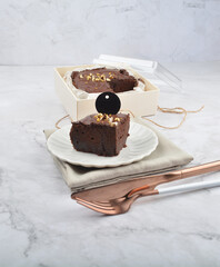 premium freshly baked dark cocoa chocolate brownie gold flower and earl grey peanut round birthday cake with walnut in wood bento box on white marble halal food sweet dessert menu for pastry cafe shop