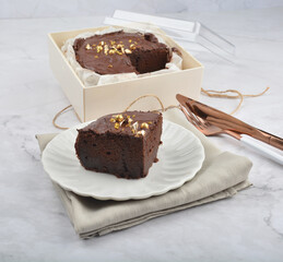 premium freshly baked dark cocoa chocolate brownie gold flower and earl grey peanut round birthday cake with walnut in wood bento box on white marble halal food sweet dessert menu for pastry cafe shop