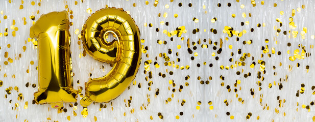 Foil balloon number and digit nineteen 19. Birthday greeting card. Golden balloons on white...