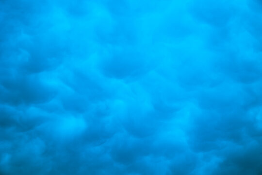 Blue toned mammatus clouds in full frame view.