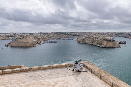 A cannon is aimed at the three cities across the bay in Valletta, Malta