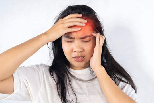 Asian girl with headache holding her head. monochrome image with red spots of pain.