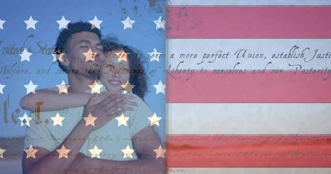 Animation of american flag and constitution over happy diverse couple embracing on sunny beach