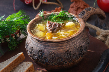 cabbage soup in a clay pot. Traditional Russian soup of sauerkraut and white cabbage, meat and...