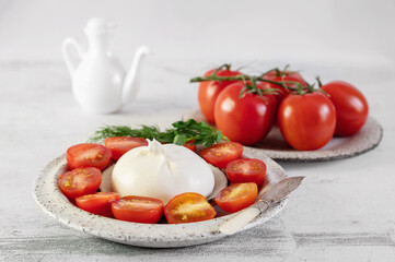 Mild burrata cheese. Burrata cheese served with cherry tomatoes and olive oil.