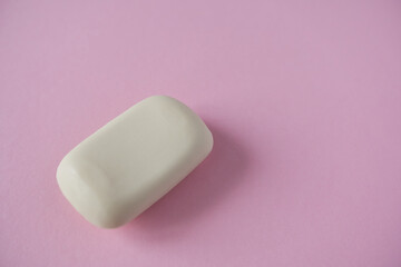 White soap bar on pink background. Minimal style. Top view.