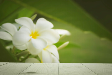 wooden table and fragipani blur background