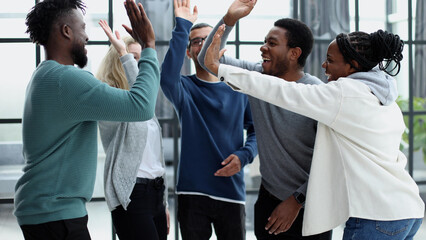 Group of happy colleagues feel motivated giving high five