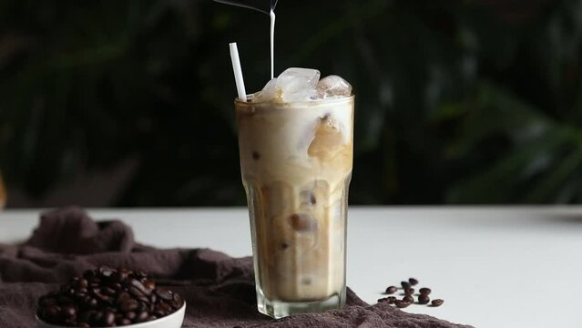  pouring milk making iced latte coffee Summer drink.