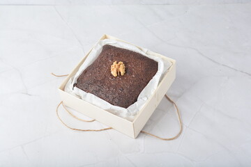 premium freshly baked dark cocoa chocolate brownie square birthday cake with walnut peanut almond in wood bento box on white marble halal food gluten free sweet dessert menu for pastry cafe shop