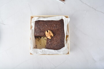 premium freshly baked dark cocoa chocolate brownie square birthday cake with walnut peanut almond in wood bento box on white marble halal food gluten free sweet dessert menu for pastry cafe shop