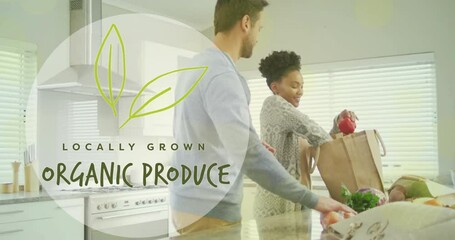 Animation of organic produce text over diverse couple preparing healthy meal in kitchen - Powered by Adobe