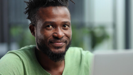 Head and shoulders portrait of contemporary African-American man smiling at camera