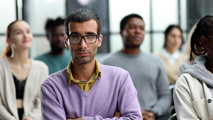 Business trainer. A man gesturing with his hand while standing in front of a group of people