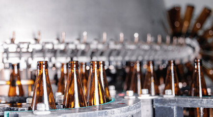 Precision Beer bottling machinery with empty bottles at brewery, modern conveyor line of food...