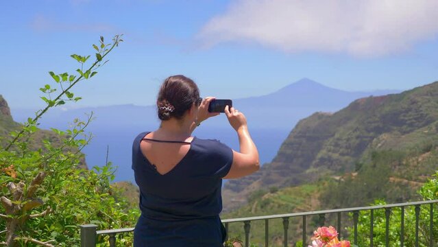 Woman takes picture of panorama view in Gomera island in 4k slow motion 60fps