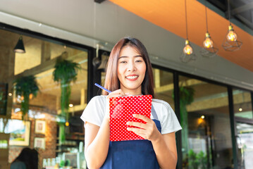 Smiling waitress wear apron hold notepad pen take order talk to clients serving restaurant guests couple choosing food drinks good customer service