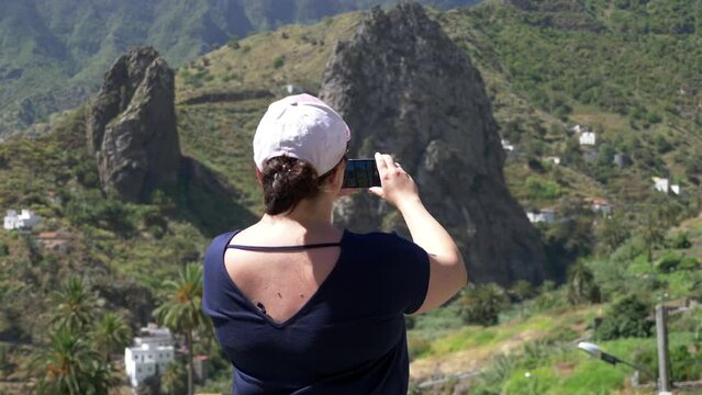 Woman takes picture of panorama view in Gomera island in 4k slow motion 60fps