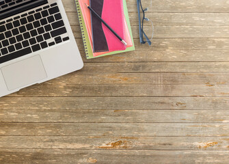 Notebook and laptop with pencil on wooden table