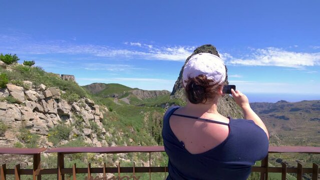 Woman takes picture of Roque de Agando in Spain in 4k slow motion 60fps