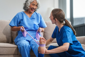 A young Caucasian physical therapist and an elderly Asian woman in her 60s attended a physical...