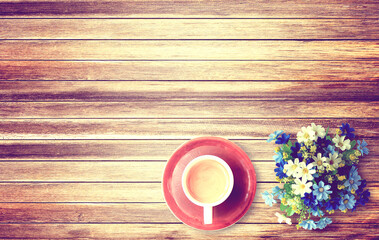 Cup of coffee and flower on wooden table background