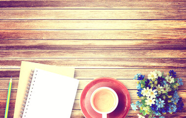 Cup of coffee and flower on wooden table background