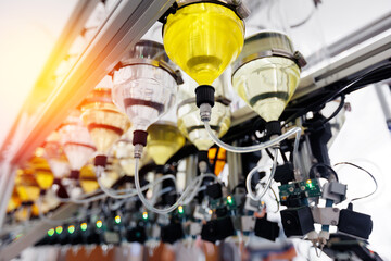 Perfume manufacturing process, overhead view of high tech filling bottles of aroma oil assembly...