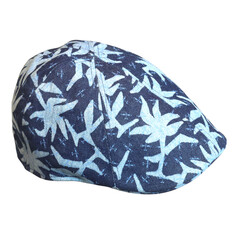 Close-up of a trendy flat cap with a unique denim texture and white leaf print design