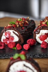 Sweet chocolate roll with whipped cream and raspberries