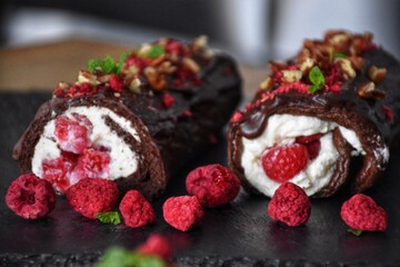 Sweet chocolate roll with whipped cream and raspberries