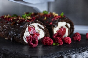 Sweet chocolate roll with whipped cream and raspberries