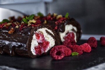 Sweet chocolate roll with whipped cream and raspberries