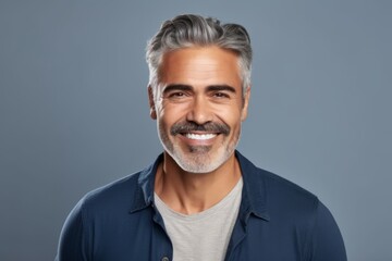 Handsome mature man with grey hair and beard smiling at camera