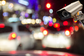 Image of CCTV security camera on blurred night street background.
