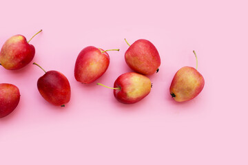 Fresh small red apples on pink background