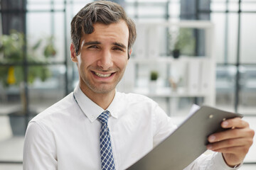 Fototapeta premium Confident businessman with black folder in the office