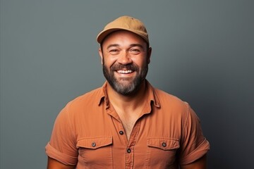 Portrait of a smiling man in cap and t-shirt against grey background