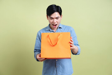 Obraz premium Photo of young Asian man on green background
