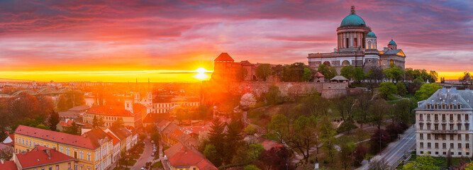 Sunset behind the basilica of Esztergom in Hungary, colourful rainy clouds above. Panorama picture.