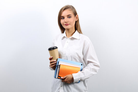 Cute woman secretary with brown hair holding a tablet and a cup of coffee