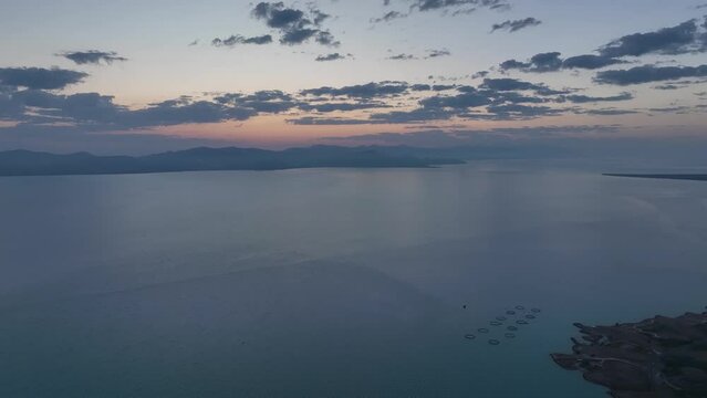 Scenic sunset or sunrise over Sevan lake popular holiday destination in Armenia, Caucasus, West Asia. Daytime Timelapse of moving white, grey clouds over lake Sevan on background hills