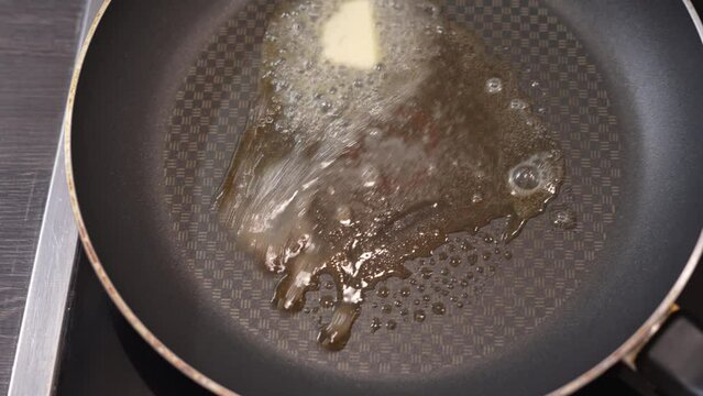 Hot butter melting in a frying pan bubbling hot with steam