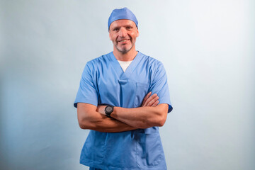 Portrait of a physiotherapist in light blue gown looking at camera in studio.