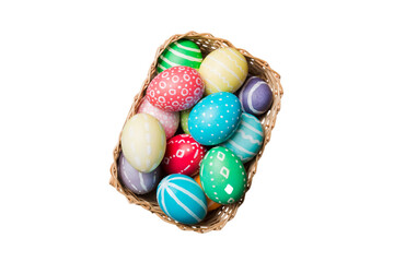 Basket of colorful Easter eggs isolated on white background. Easter basket filled with colored eggs top view holiday concept