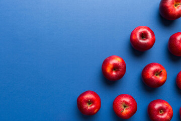 Many red apples on colored background, top view. Autumn pattern with fresh apple above view with copy space for design or text