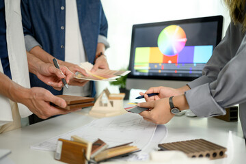 Interior designers working with material sample and color swatches on office table